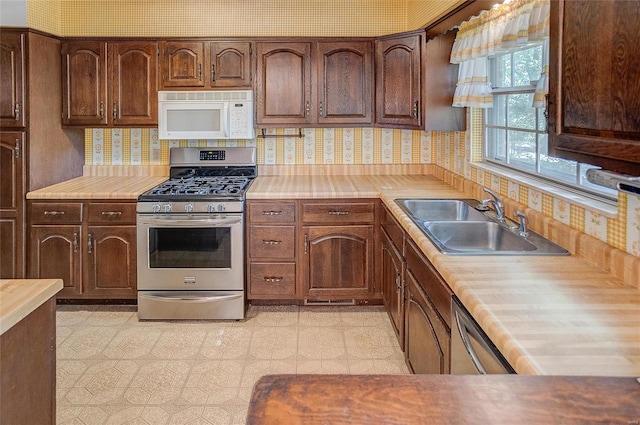 kitchen featuring tasteful backsplash, wooden counters, stainless steel appliances, and sink