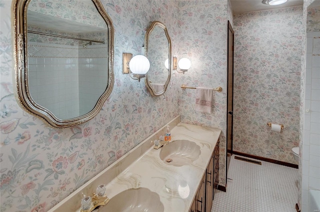 bathroom with vanity, tiled shower, toilet, and tile patterned floors