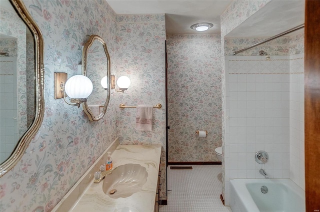 full bathroom with vanity, tiled shower / bath, toilet, and tile patterned flooring