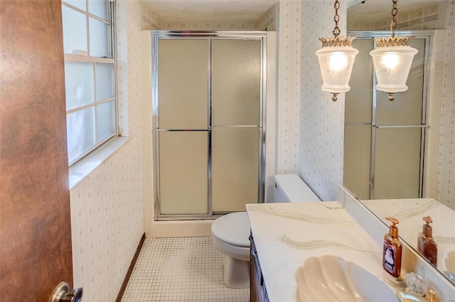 bathroom with vanity, toilet, a shower with shower door, and tile patterned flooring