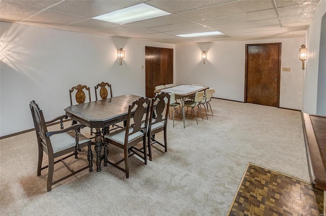 dining room featuring a drop ceiling and carpet flooring