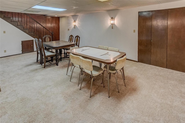 carpeted dining space featuring a drop ceiling