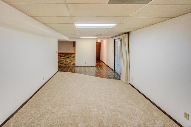 carpeted spare room with a paneled ceiling