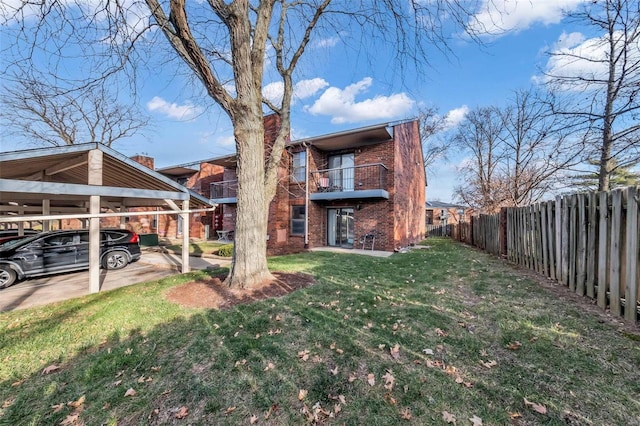 view of yard featuring a carport and a balcony