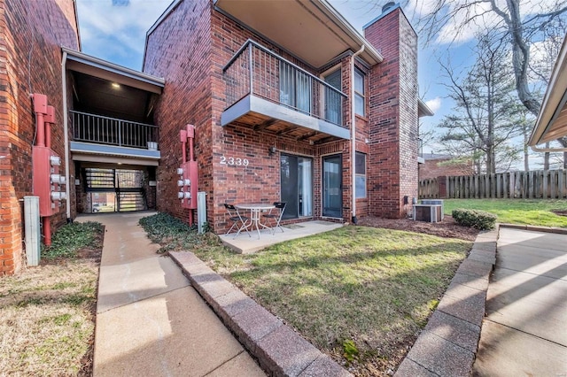 property entrance with central AC, a patio, and a lawn