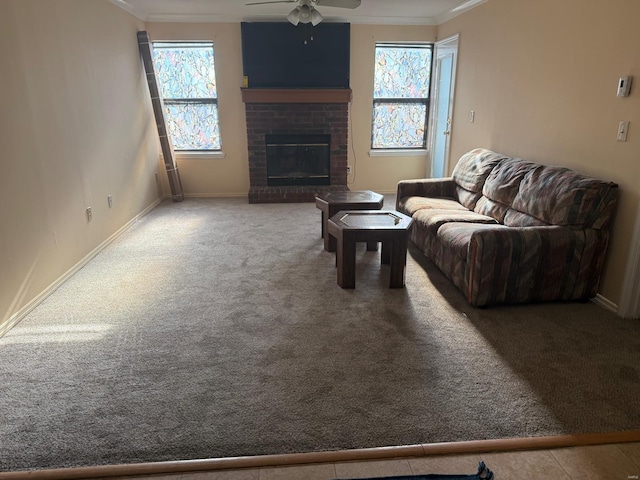 carpeted living room with crown molding, ceiling fan, and a fireplace