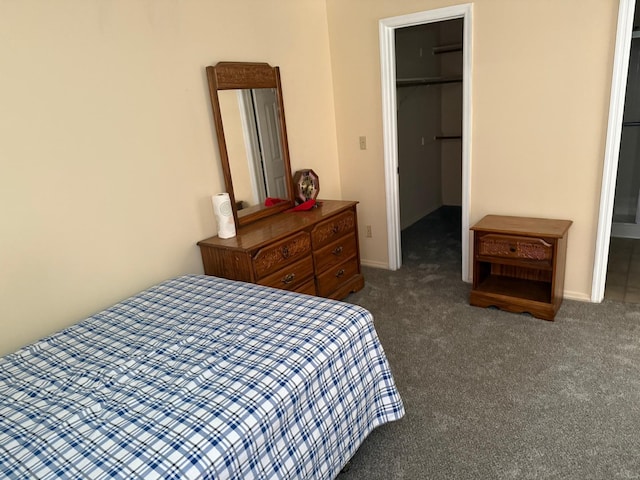 carpeted bedroom featuring a walk in closet and a closet