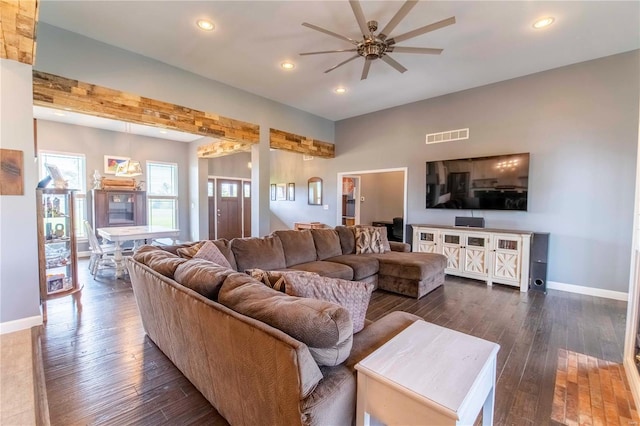 living room featuring ceiling fan and dark wood-type flooring