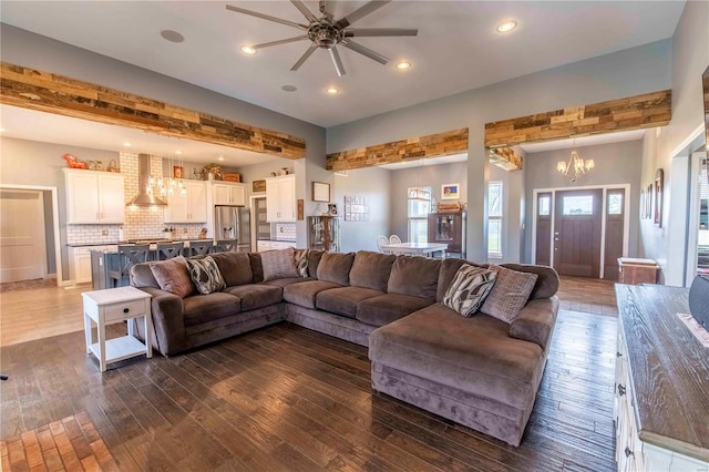 living room featuring ceiling fan with notable chandelier and dark hardwood / wood-style flooring