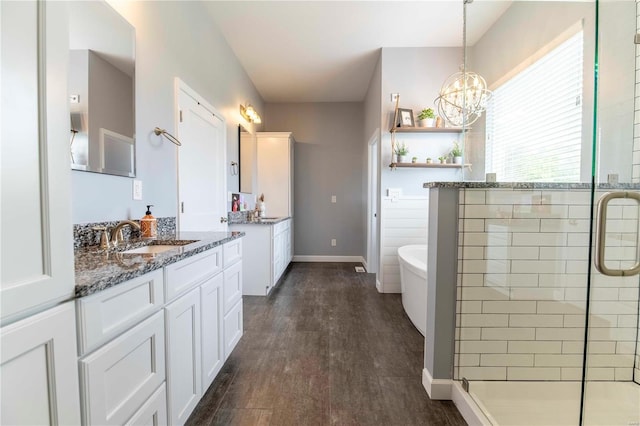 bathroom with independent shower and bath, vanity, a notable chandelier, and hardwood / wood-style flooring