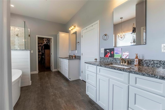 bathroom with shower with separate bathtub, wood-type flooring, an inviting chandelier, and vanity