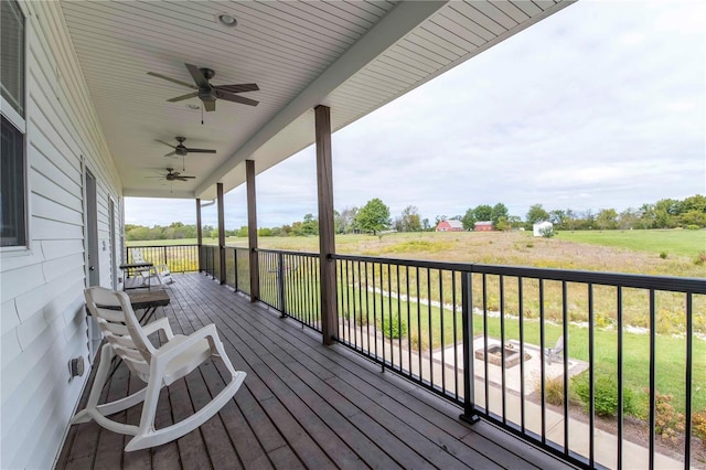 wooden terrace with a lawn and ceiling fan