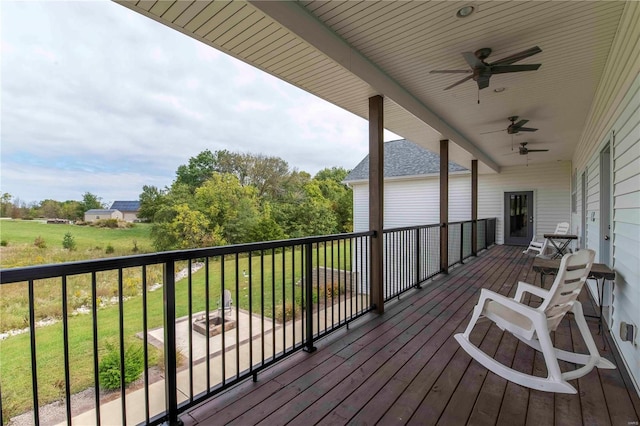 wooden terrace with a lawn and ceiling fan