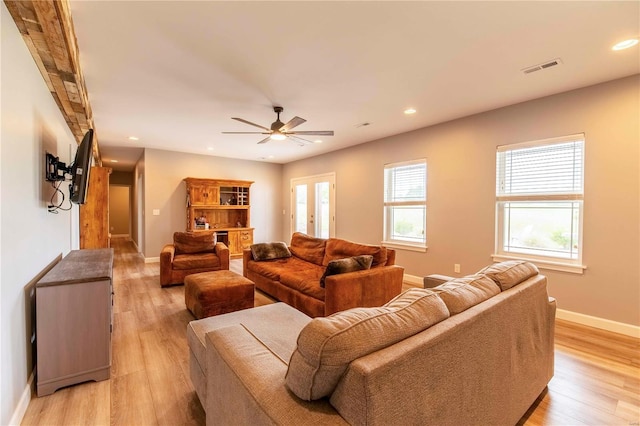 living room featuring ceiling fan, light hardwood / wood-style flooring, and french doors