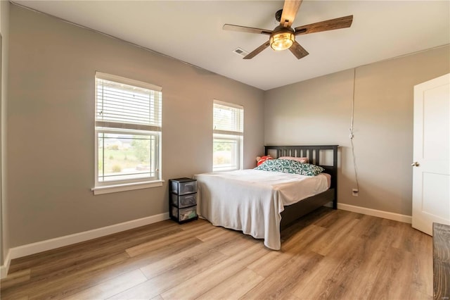 bedroom with light hardwood / wood-style floors and ceiling fan