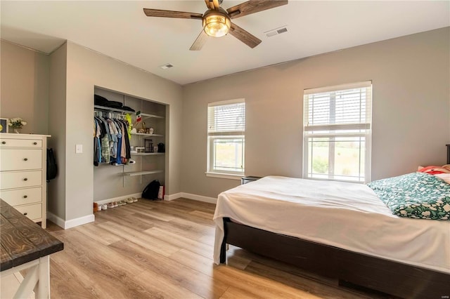 bedroom featuring light hardwood / wood-style floors, ceiling fan, and a closet