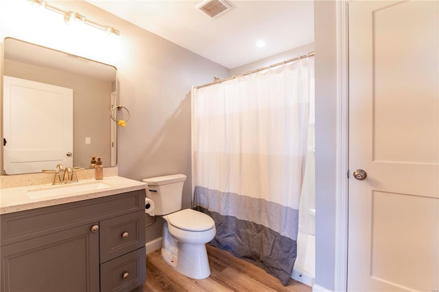 full bathroom featuring shower / bath combo, hardwood / wood-style flooring, vanity, and toilet