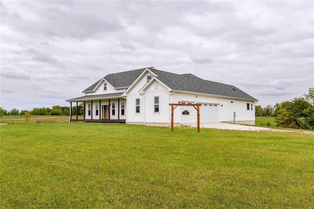 view of front of home with a garage, a front lawn, and covered porch