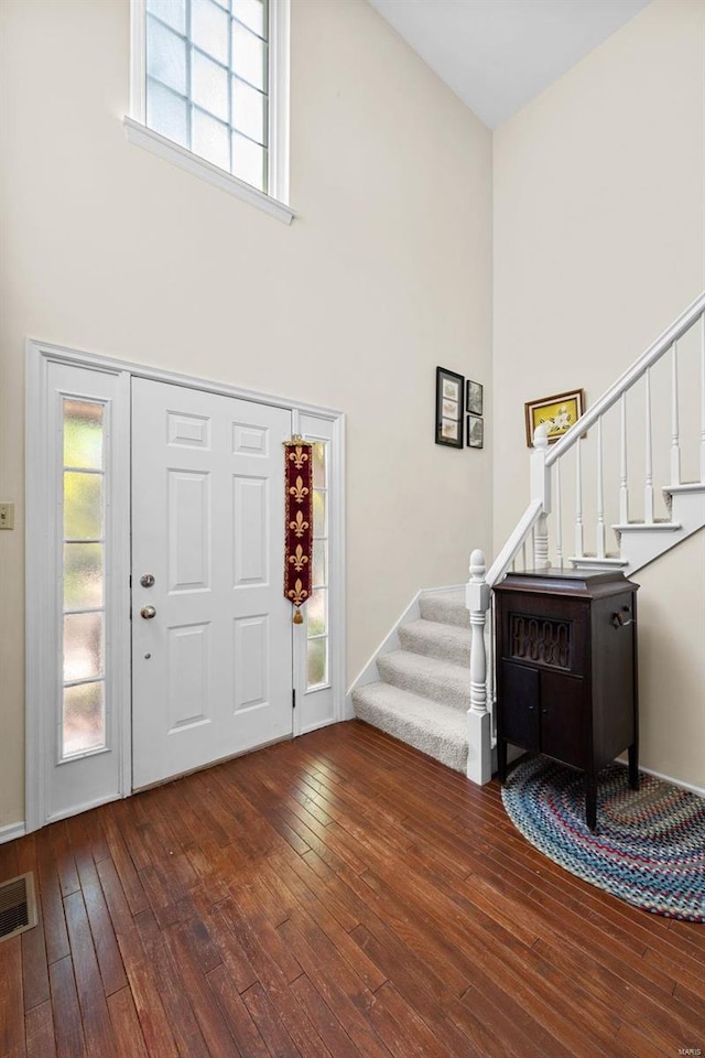 entrance foyer with hardwood / wood-style floors and a high ceiling