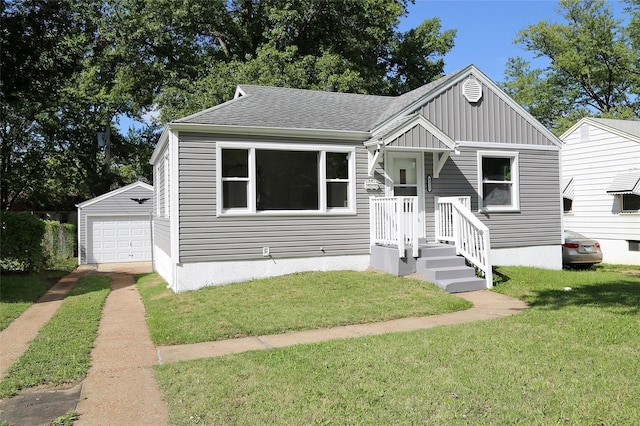 view of front of property with an outdoor structure, a garage, and a front lawn