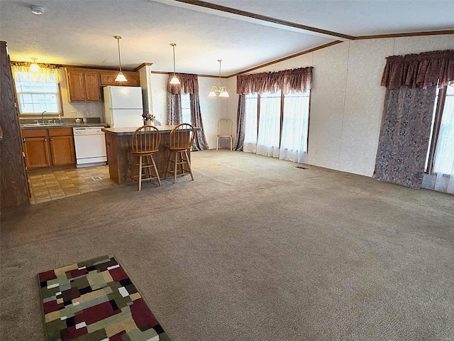 kitchen with sink, vaulted ceiling, white appliances, and a healthy amount of sunlight