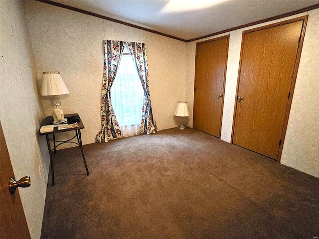 unfurnished bedroom featuring lofted ceiling, carpet flooring, a textured ceiling, two closets, and crown molding