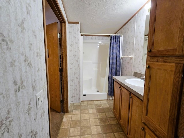 bathroom featuring a shower with curtain, vanity, ornamental molding, and a textured ceiling