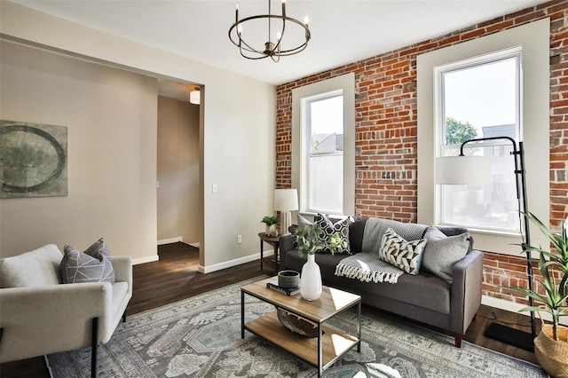 living room featuring brick wall, plenty of natural light, and hardwood / wood-style floors