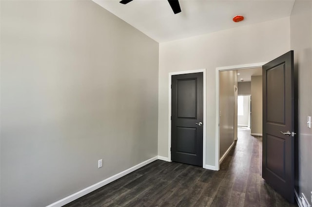 spare room with ceiling fan and dark wood-type flooring