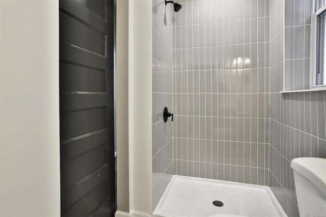 bathroom with toilet and tiled shower