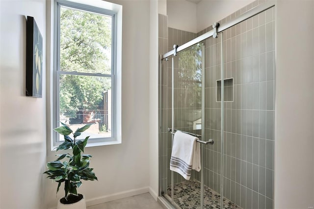 bathroom with a healthy amount of sunlight, tile patterned flooring, and an enclosed shower