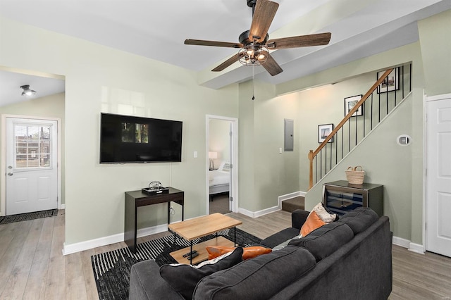 living room featuring electric panel, light hardwood / wood-style flooring, lofted ceiling, and ceiling fan