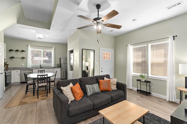 living room featuring ceiling fan and light hardwood / wood-style flooring