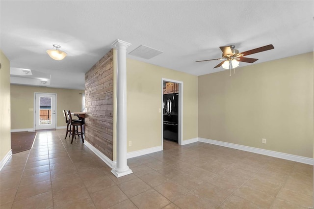 spare room with decorative columns, light tile patterned floors, a textured ceiling, and ceiling fan