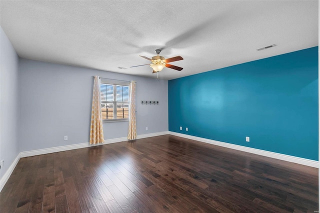 empty room with a textured ceiling, dark hardwood / wood-style floors, and ceiling fan