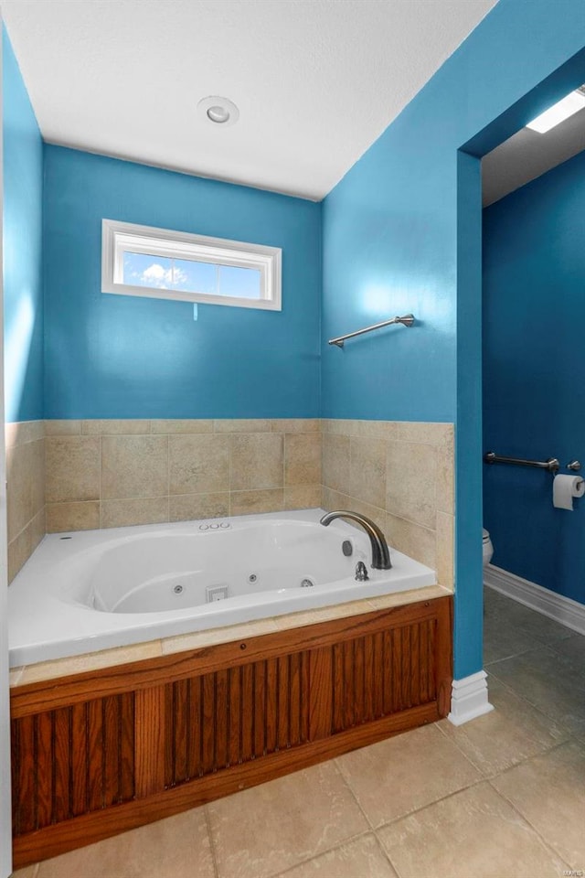 bathroom with tile patterned flooring, a bathing tub, and toilet