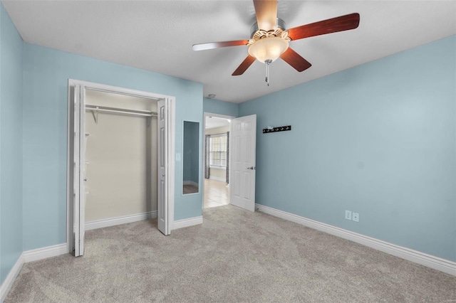 unfurnished bedroom with light colored carpet, a closet, and ceiling fan