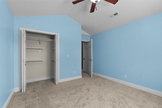 unfurnished bedroom featuring light carpet, lofted ceiling, a closet, and ceiling fan