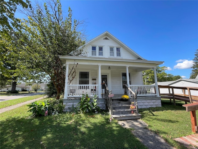 bungalow with a porch and a front lawn