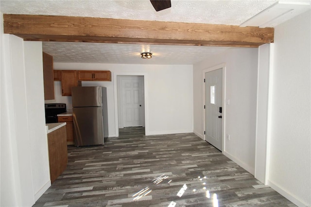 kitchen with black electric range oven, stainless steel fridge, beam ceiling, a textured ceiling, and dark wood-type flooring