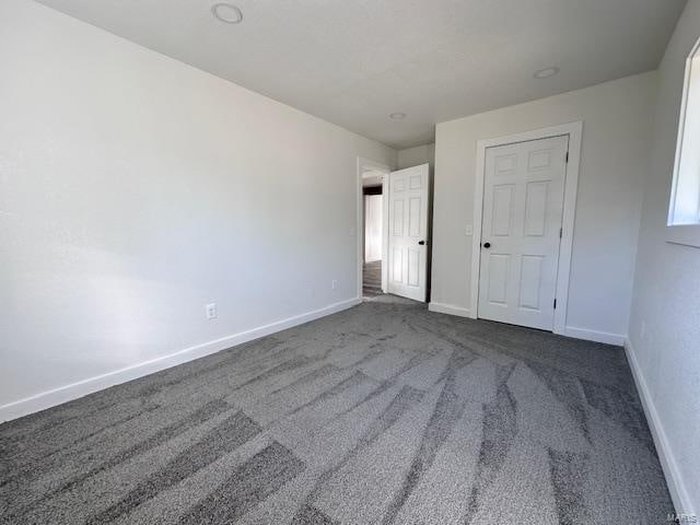 unfurnished bedroom featuring dark carpet