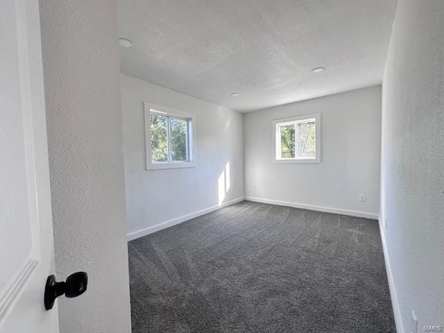 carpeted spare room with a textured ceiling