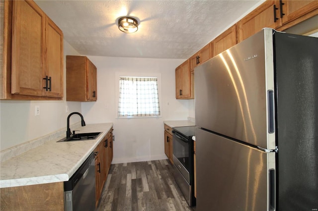 kitchen featuring a textured ceiling, stainless steel appliances, sink, and dark hardwood / wood-style flooring