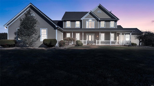 view of front of home featuring covered porch and a yard