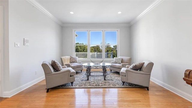 living room with light wood-type flooring and ornamental molding