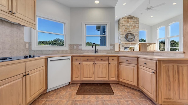 kitchen featuring backsplash, black electric cooktop, lofted ceiling, white dishwasher, and sink