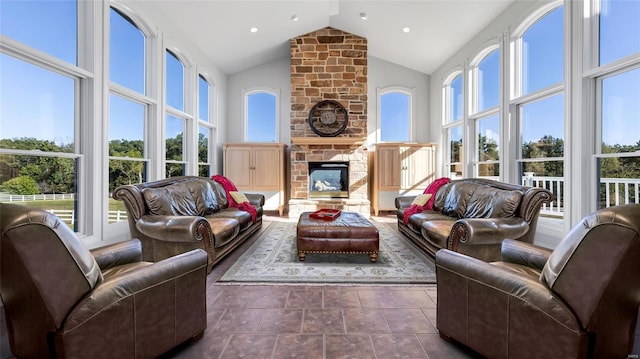 living room featuring high vaulted ceiling, a wealth of natural light, and a fireplace