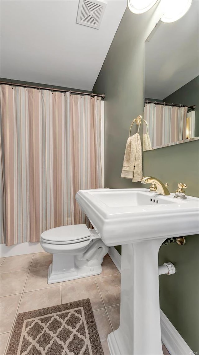 bathroom featuring vaulted ceiling, toilet, and tile patterned flooring