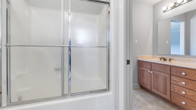 bathroom featuring combined bath / shower with glass door, vanity, and tile patterned flooring