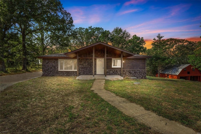 ranch-style house featuring an outdoor structure and a lawn